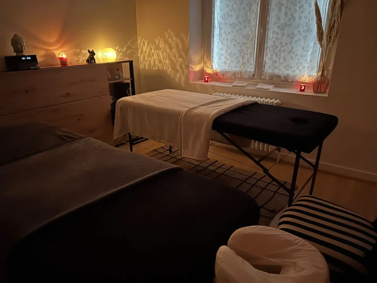 Salle préparée pour un massage en duo, ambiance tamisée.